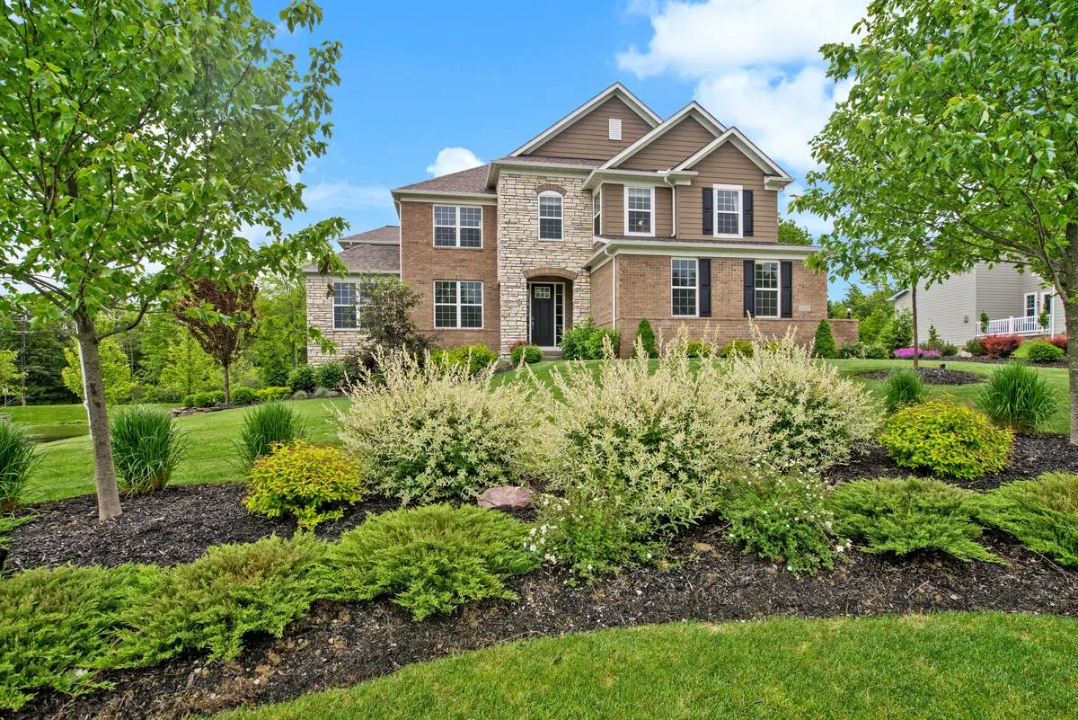 Professionally landscaped front yard with manicured lawn, shrubs, and planting beds Professionally landscaped front yard with manicured lawn, shrubs, and planting beds